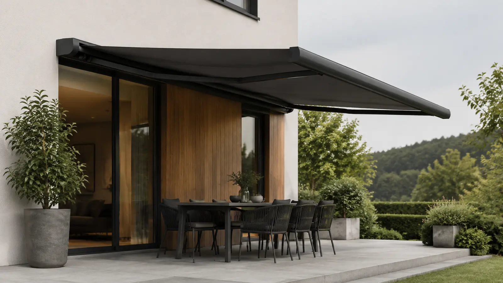Ausgefahrene dunkle Markise über einer Terrasse am Wohnhaus